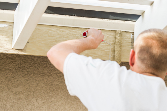 Exterior home painter painting a pergula